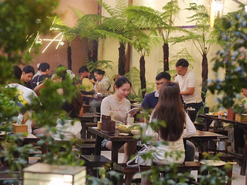 Khách ngồi ăn giữa khu cây xanh của quán