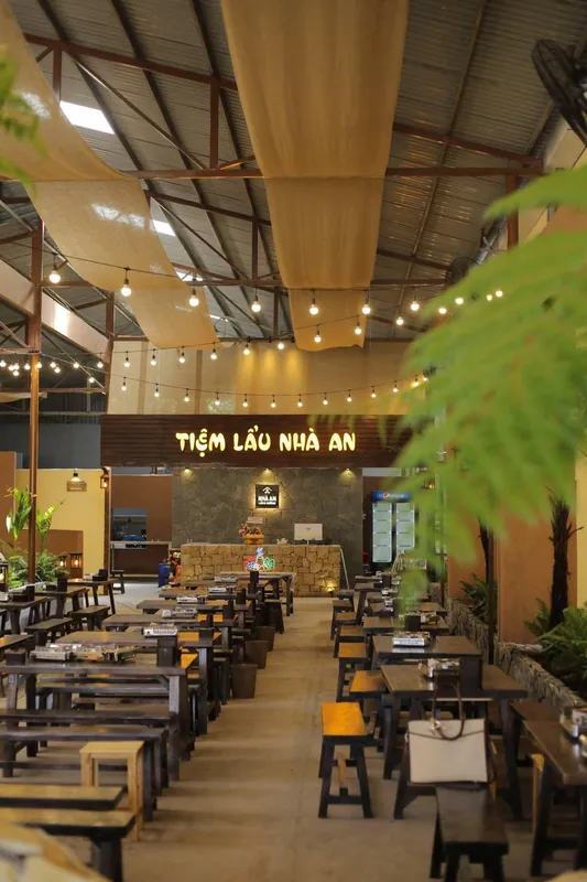 Khu trong nhà với bàn ghế gỗ và cây dương xỉ