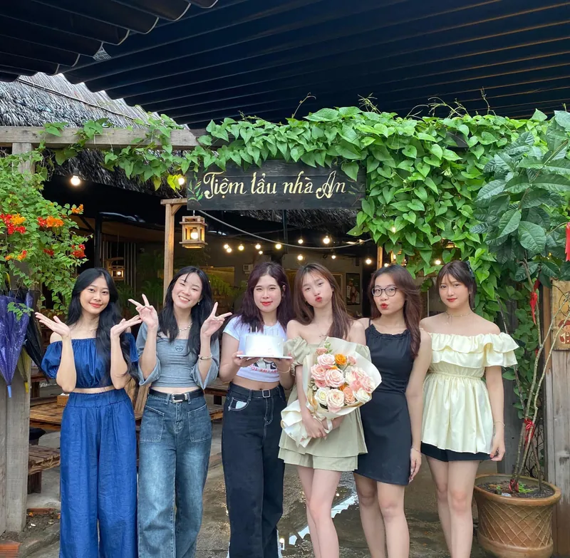Nhóm bạn nữ chụp ảnh kỷ niệm trước cổng quán