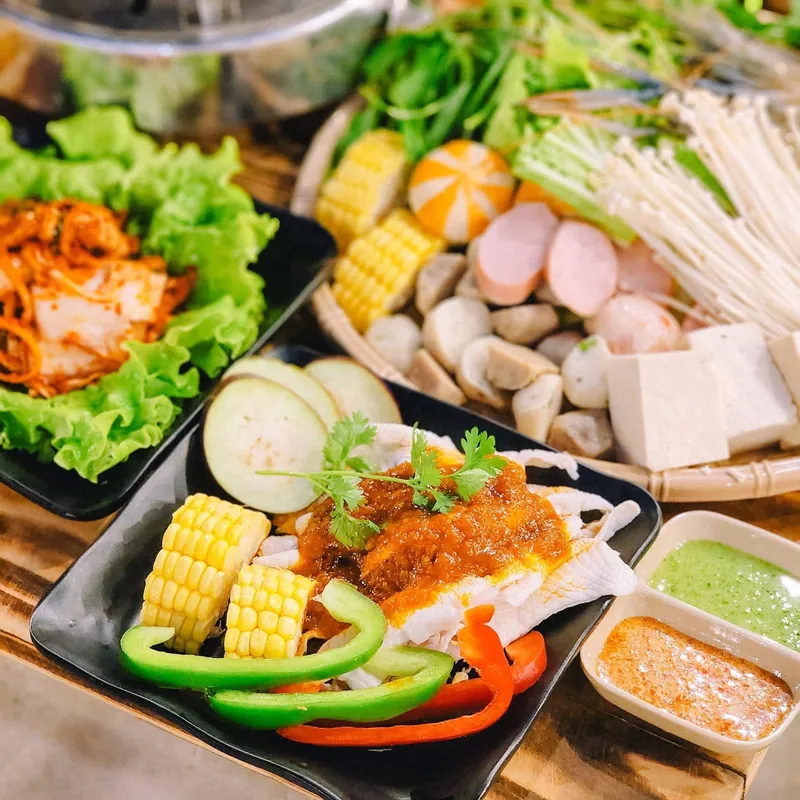 Mâm đồ nhúng nhiều màu gồm thịt bò, chả cá, bắp và rau