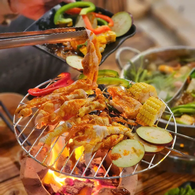 Thịt nướng vàng ruộm trên vỉ than đang cháy kèm bắp ngọt và rau củ